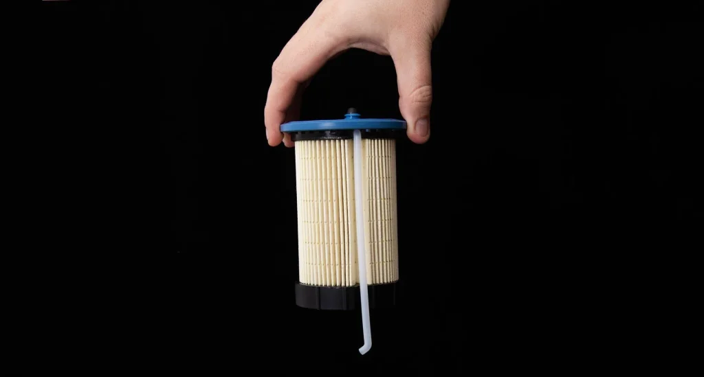 fuel filter in hand on black background close up fuel