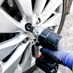 auto mechanic using impact wrench cordless to change car